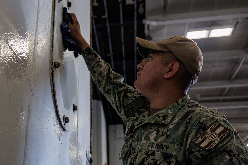 USS Theodore Roosevelt Sailor Cleans in Hangar Bay