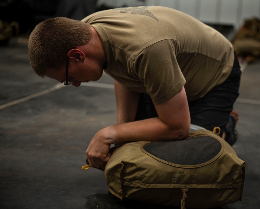 82nd ERQS Airman prepares parachutes for regional operations