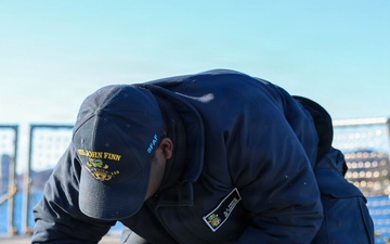 Sailors aboard the USS John Finn conduct a sea and anchor detail in Yokosuka, Japan