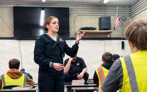 Recruiter speaks to students of school she attended before the Navy