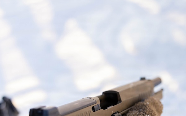 U.S. Soldier Inspects Sidearm During Weapons Qualification in Latvia