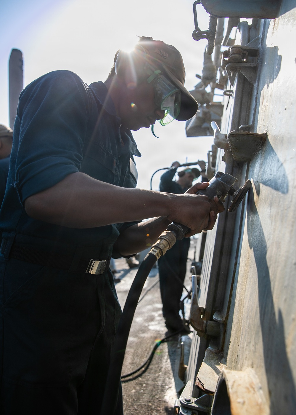 USS Mitscher (DDG 57) Sailor conducts deck preservation