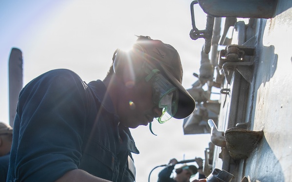 USS Mitscher (DDG 57) Sailor conducts deck preservation