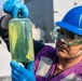USS Mitscher (DDG 57) Sailor inspects fuel sample during RAS with USNS Carl Brashear (T-AKE 7)
