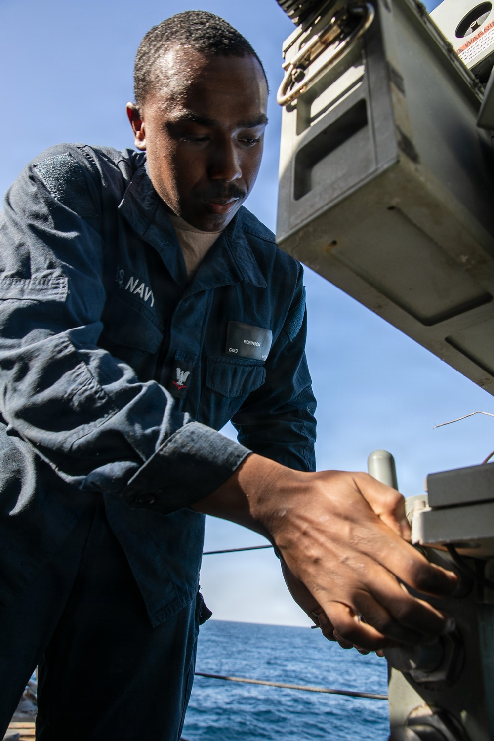 USS Mitscher (DDG 57) Sailor conducts maintenance on Mk 38 25mm gun