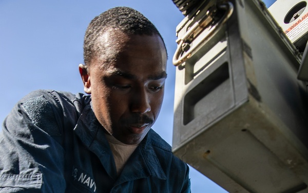 USS Mitscher (DDG 57) Sailor conducts maintenance on Mk 38 25mm gun