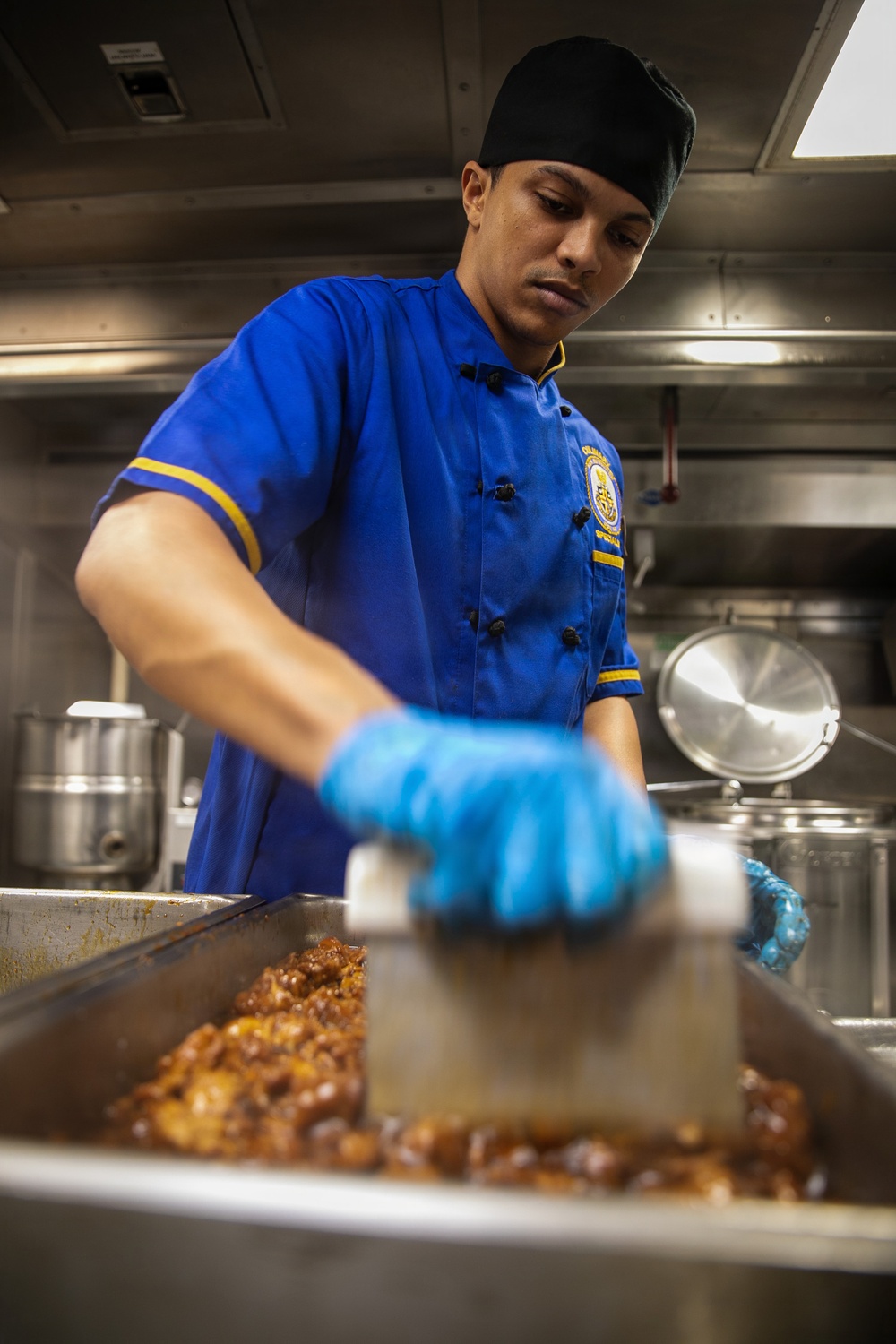 USS Mitscher (DDG 57) Sailor prepares food in ship galley