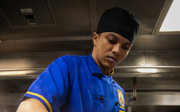 USS Mitscher (DDG 57) Sailor prepares food in ship galley