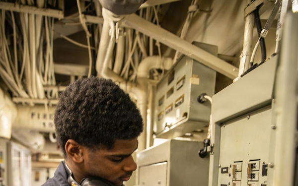 USS Mitscher (DDG 57) Sailor attaches safety tag to fuse box