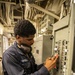 USS Mitscher (DDG 57) Sailor attaches safety tag to fuse box