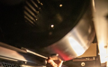 USS Mitscher (DDG 57) sailor inspects fan coil unit in HAZMAT