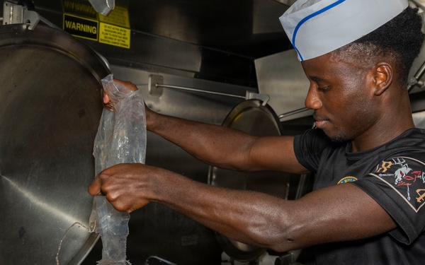 Culinary Specialists prepare dinner for the crew aboard USS Bulkeley (DDG 84)