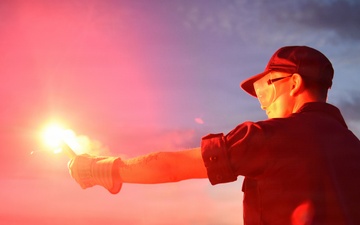 Coastguardsman Practices with Light Flare