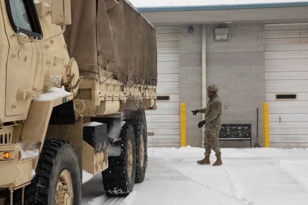 Soldier Ground Guides Light Medium Tactical Vehicle in Snow