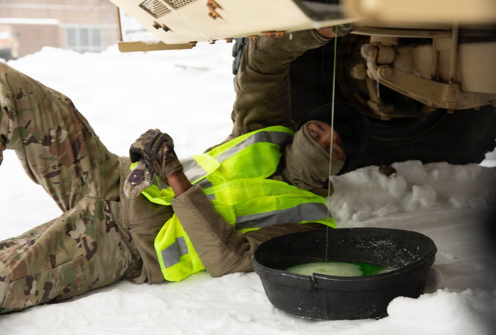 Vehicle Maintenance Conducted in Snow