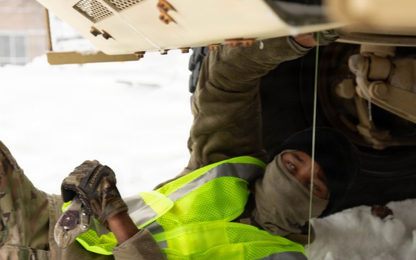 Vehicle Maintenance Conducted in Snow