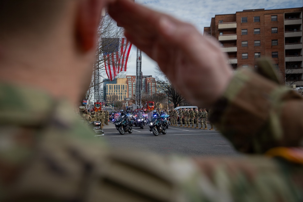 National Guard service members salute a fallen officer during a dignified escort in Washington, D.C.