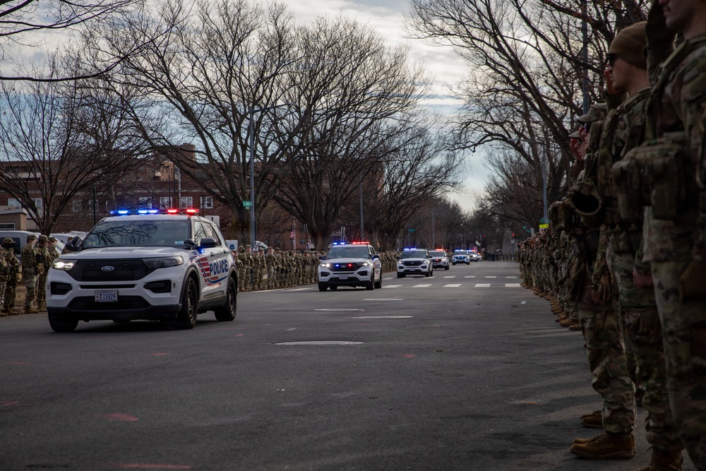 National Guard service members salute a fallen officer during a dignified escort in Washington, D.C.
