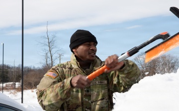 Maryland Army National Guard Soldier Cleans Snow off a Car During Operation Blur