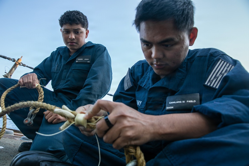 USS Mitscher (DDG 57) Sailor repairs rope on weather deck