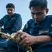 USS Mitscher (DDG 57) Sailor repairs rope on weather deck