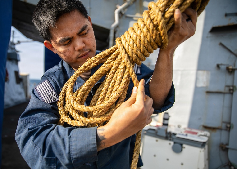 USS Mitscher (DDG 57) Sailor repairs rope on weather deck
