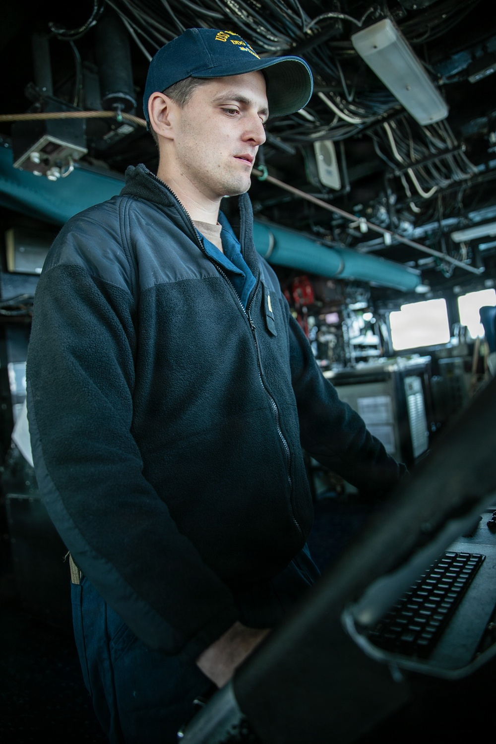 USS Mitscher (DDG 57) junior officer stands watch in ship bridge