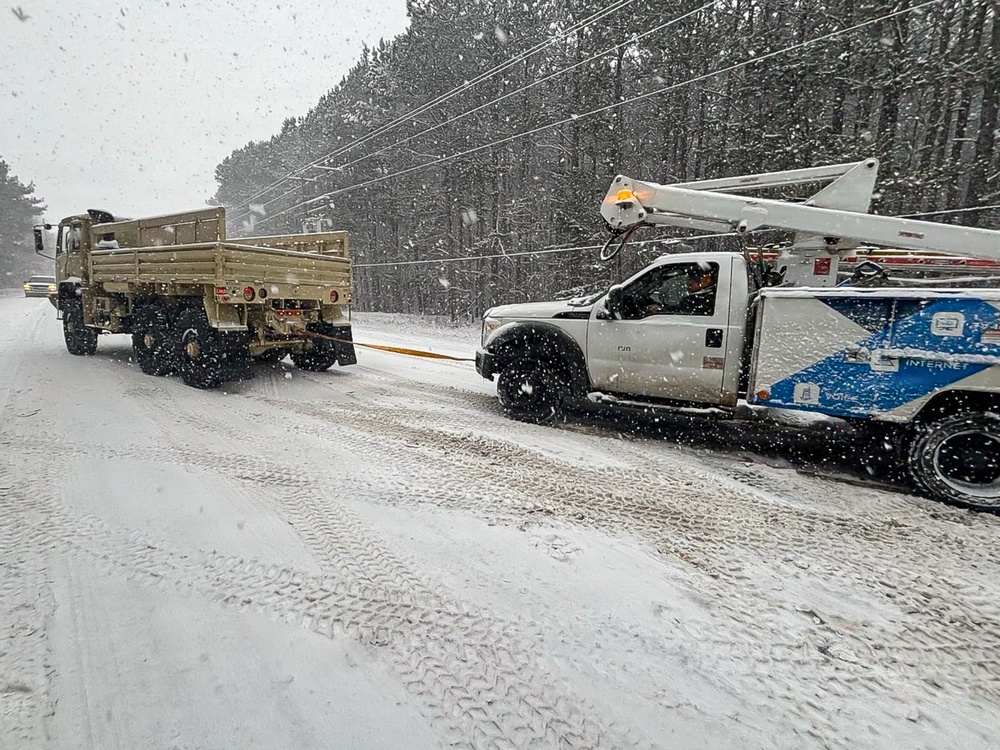 228th Theater Tactical Signal Brigade vehicle-recovery team assists a stranded vehicle during Winter Storm Gianna
