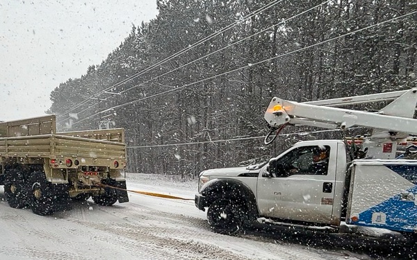228th Theater Tactical Signal Brigade vehicle-recovery team assists a stranded vehicle during Winter Storm Gianna