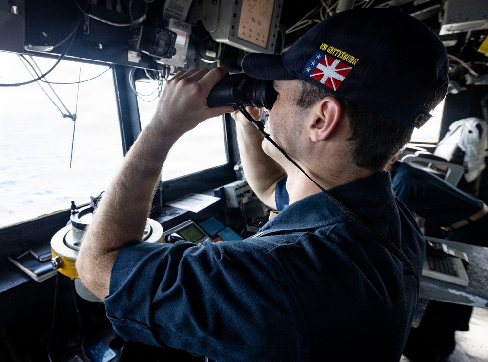 U.S. Sailor Uses Binoculars in the Pilot House