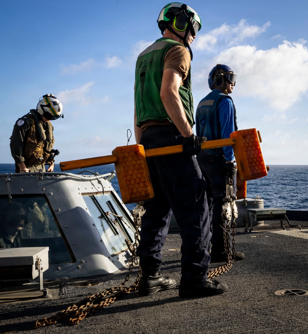 U.S. Sailors Prepare to Chock and Chain an MH-60R Sea Hawk Helicopter on the Flight Deck