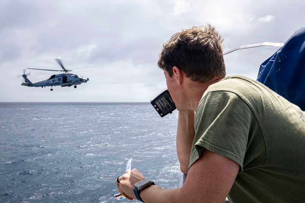 U.S. Sailor Radios an MH-60R Sea Hawk Helicopter on the Bridge Wing