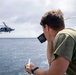 U.S. Sailor Radios an MH-60R Sea Hawk Helicopter on the Bridge Wing