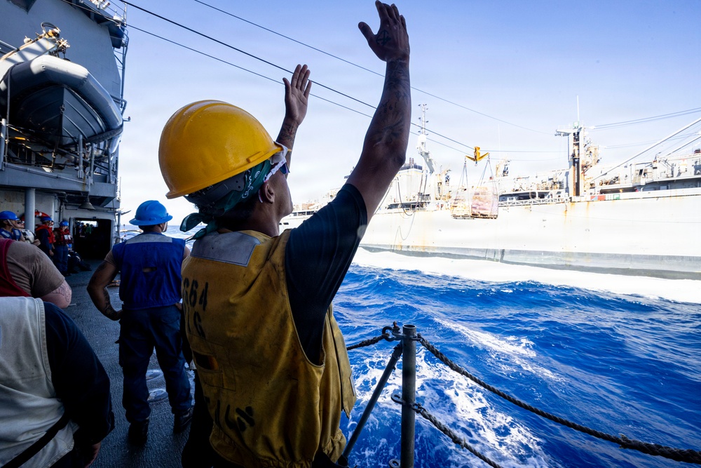 A U.S. Sailor Signals to Fast Combat Support Ship USNS Supply (T-AOE 6)