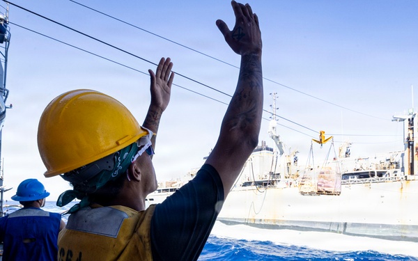 A U.S. Sailor Signals to Fast Combat Support Ship USNS Supply (T-AOE 6)