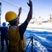 A U.S. Sailor Signals to Fast Combat Support Ship USNS Supply (T-AOE 6)