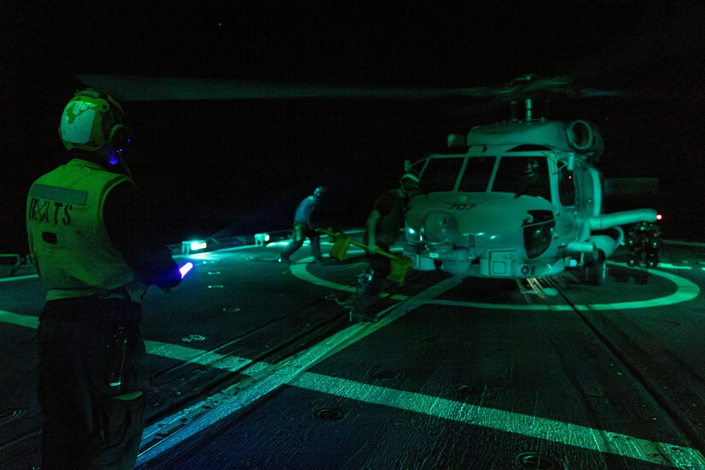U.S. Sailors Chock and Chain an MH-60R Sea Hawk Helicopter on the Flight Deck