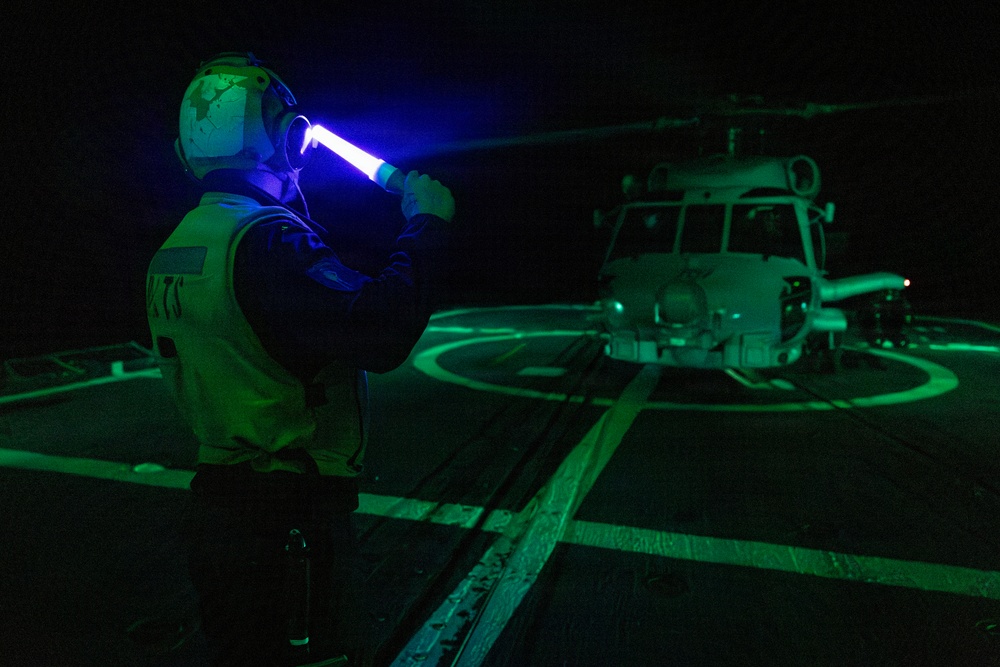 A U.S. Sailor Signals an MH-60R Sea Hawk Helicopter on the Flight Deck
