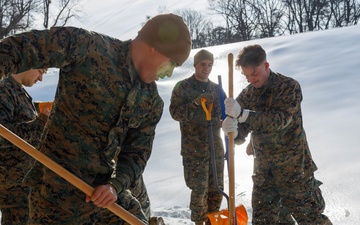 U.S. Marines with Marine Corps Base Quantico Shovel Snow for the Crossroads Elementary School
