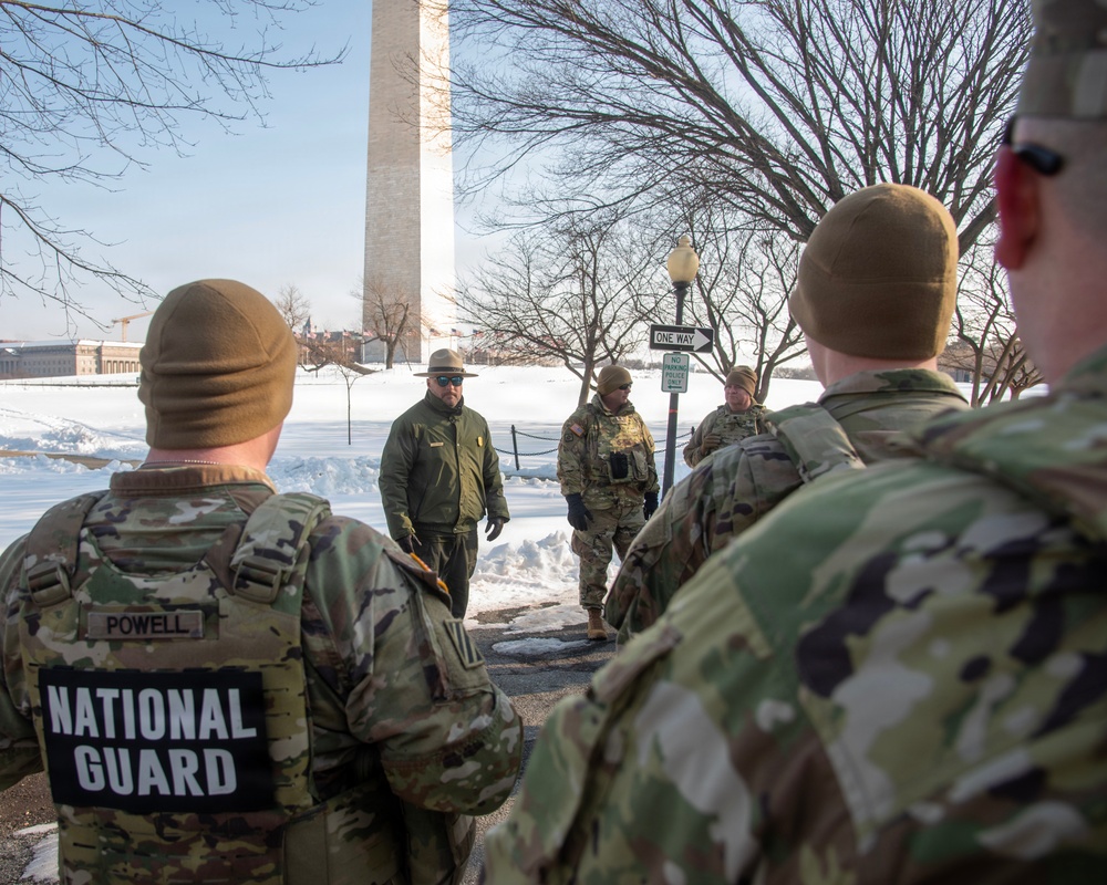 Service members clear snow at the Washington Monument