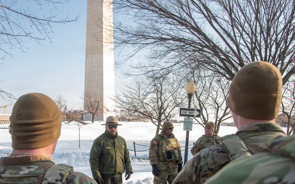 Service members clear snow at the Washington Monument