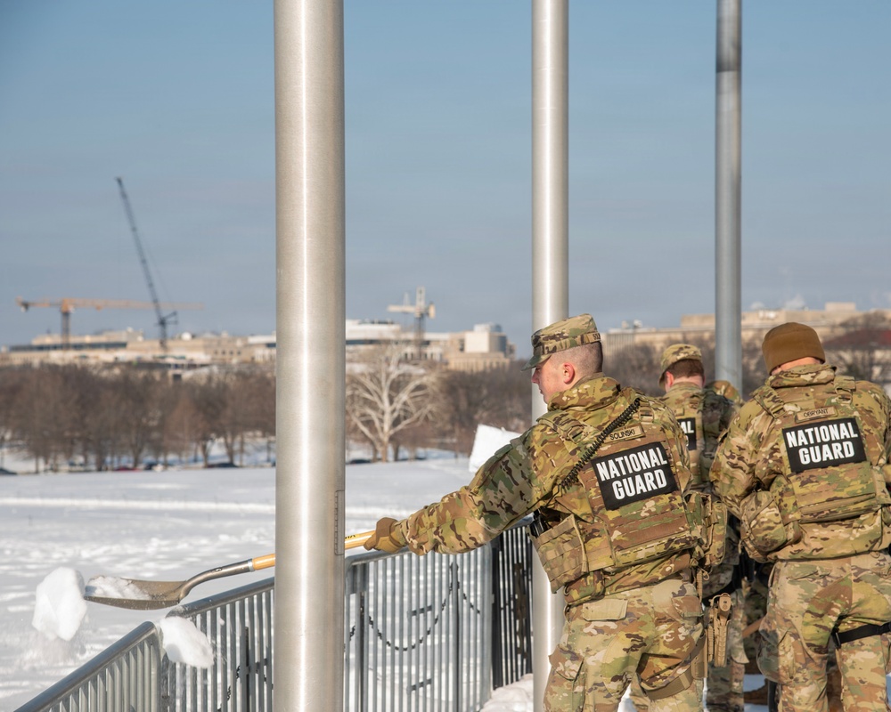 Service members clear snow at the Washington Monument