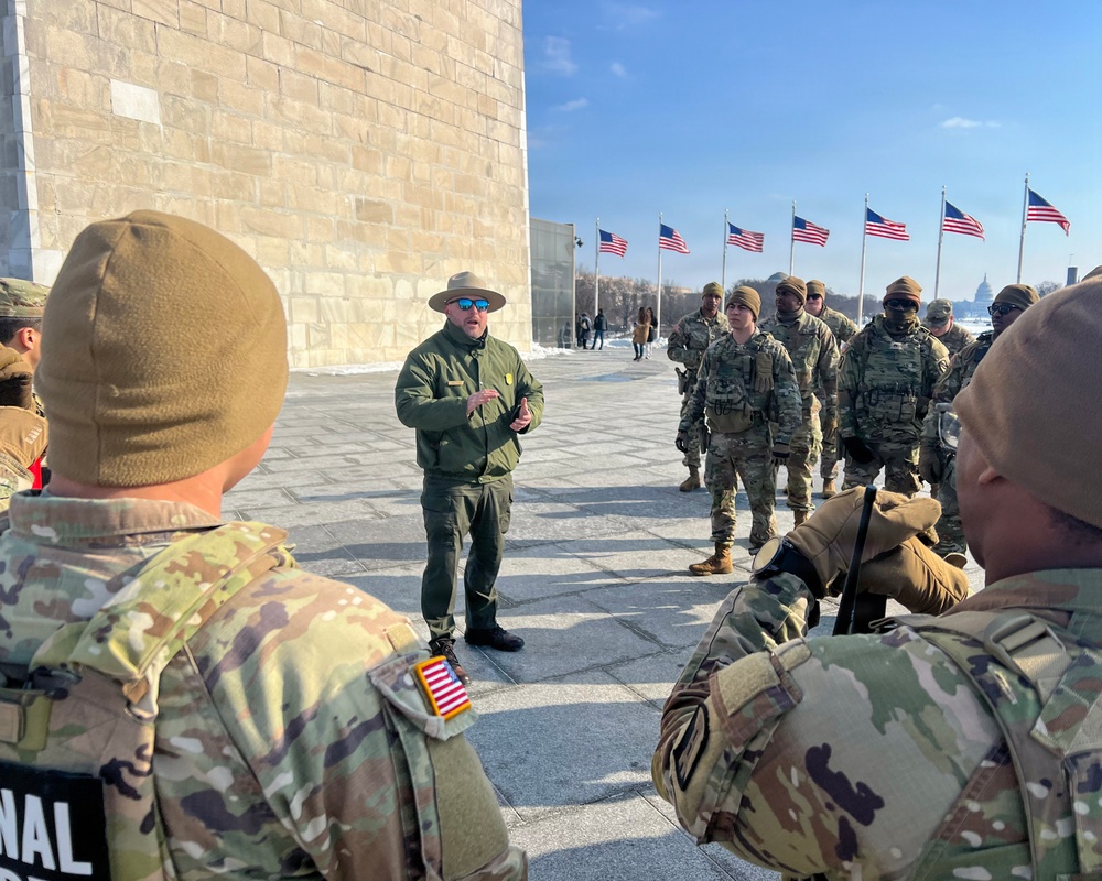Service members clear snow at the Washington Monument