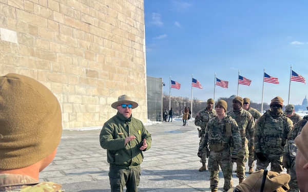 Service members clear snow at the Washington Monument
