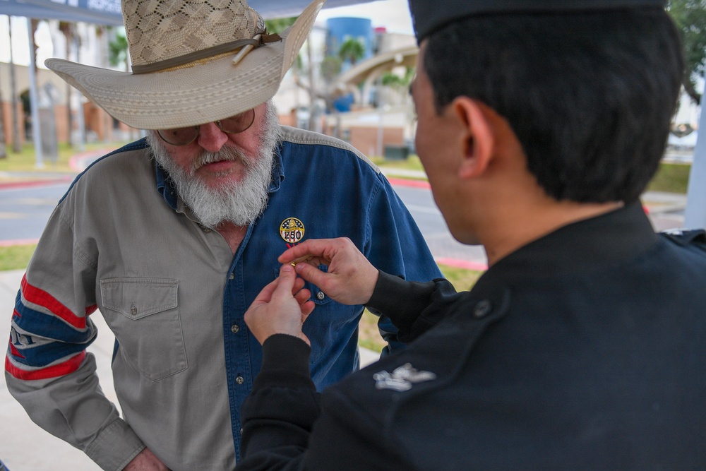 HM2 Ahn pins a Navy 250 pin on a civilian's shirt
