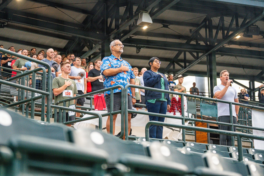 Coast Guard members and Cvillians stand for the national anthem