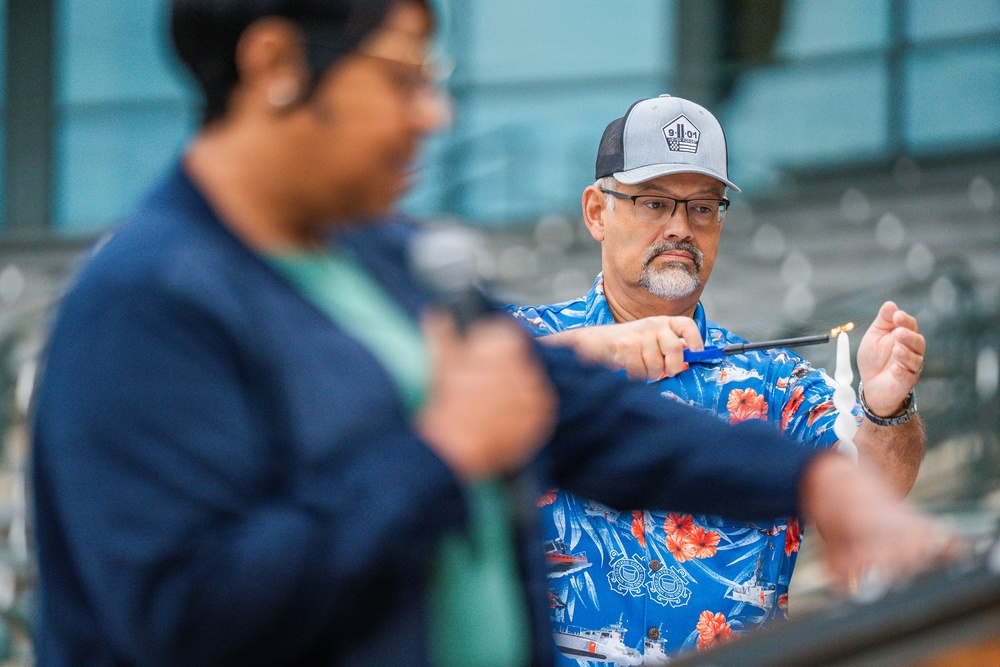 A Coast Guard Civilian lights a candle in rememberance of the victims of 9/11