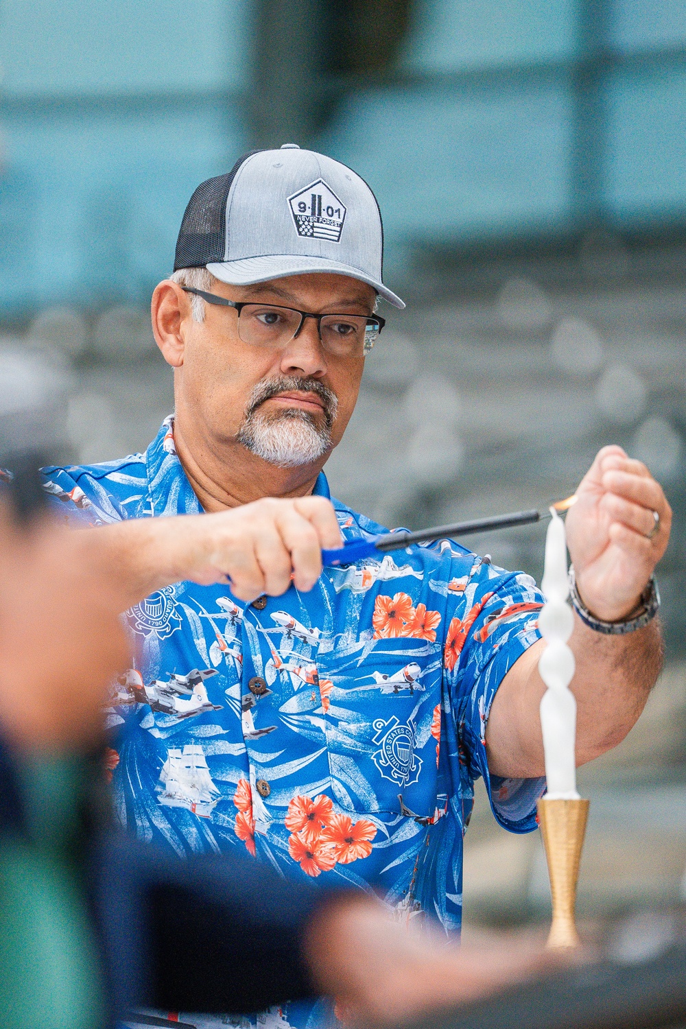 A Coast Guard civillian lights a candle in rememberance of 9/11