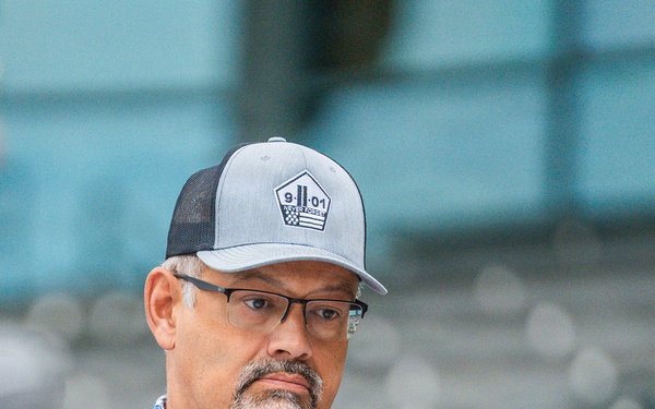 A Coast Guard civillian lights a candle in rememberance of 9/11