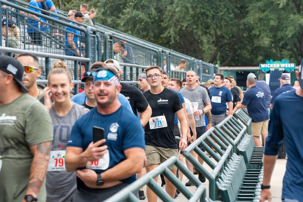 A line of participants weave in and out of the bleacher stairs